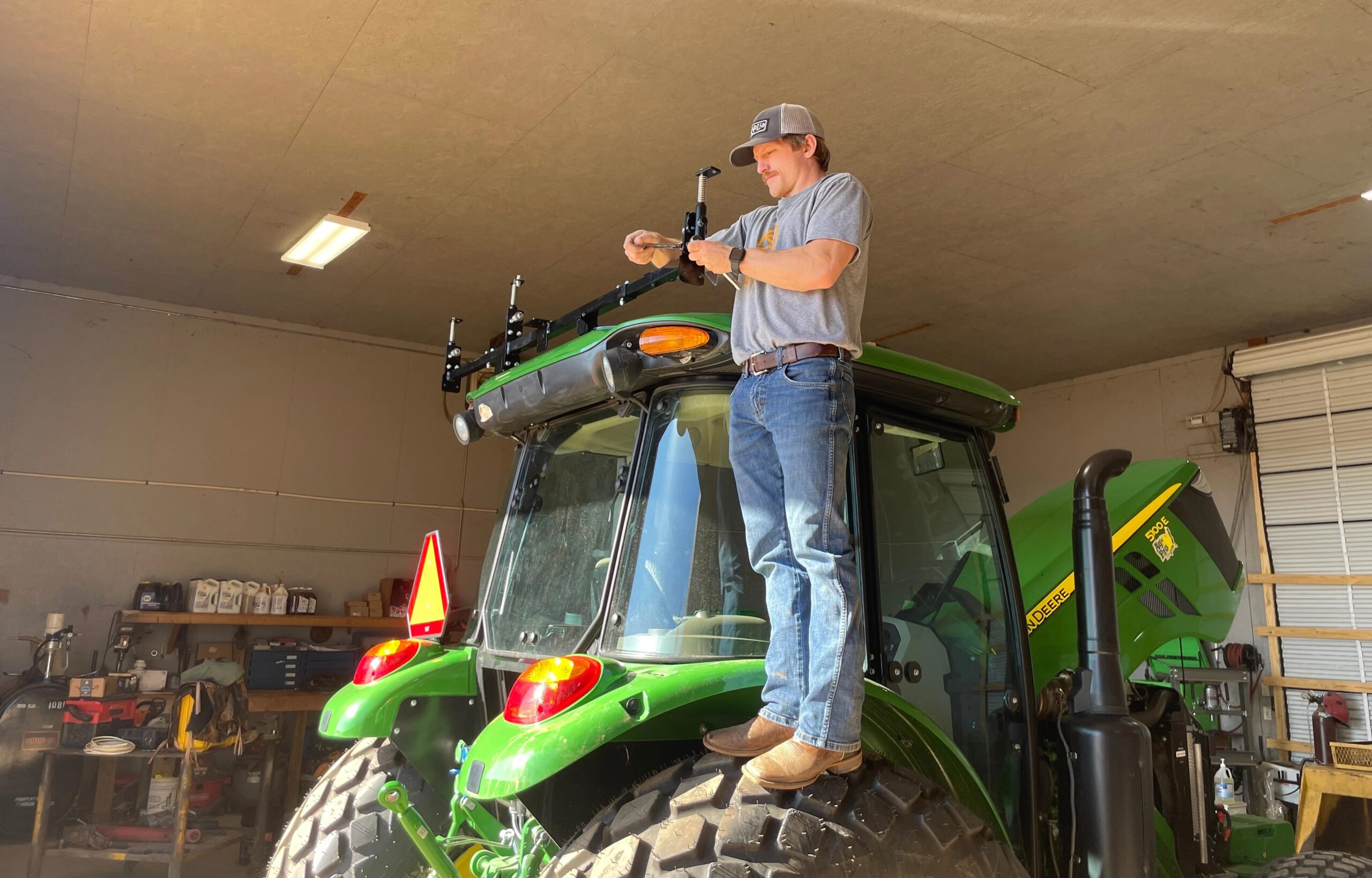 Logan Mays performs a hardware installation on a customer tractor.